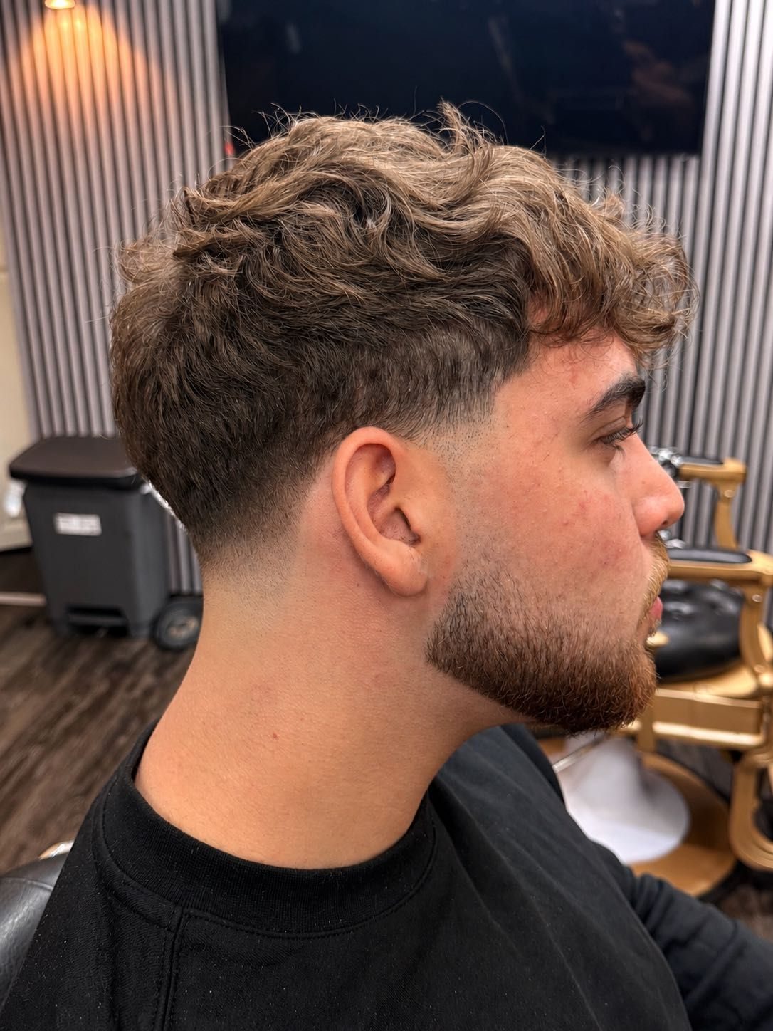 Curly textured top with a clean taper, side view