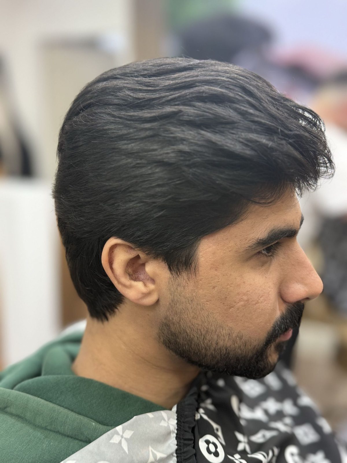 Slicked back medium length cut with a shaped beard